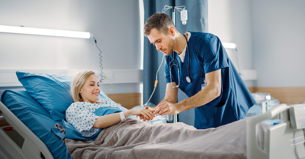 Hospital employee treating patient in hospital bed